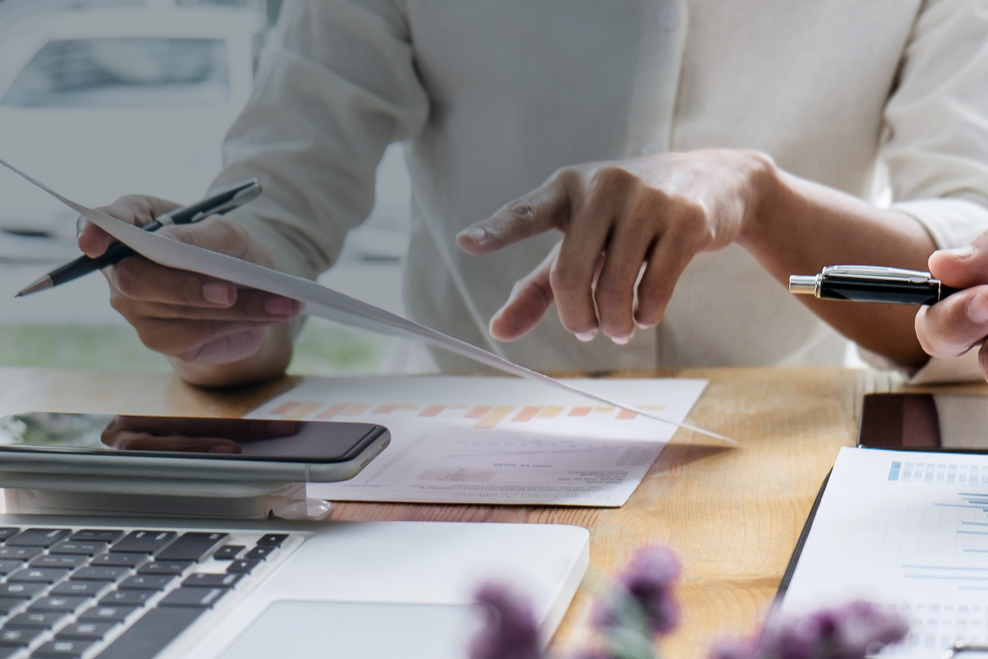 Hands shown busily working on paperwork